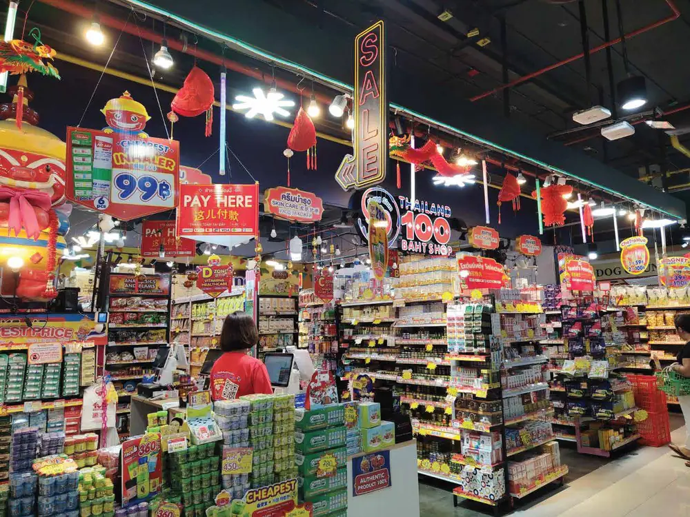 ภายในสาขาประดับโคมแดงและป้ายไฟ SALE มีพนักงานเสื้อแดงอยู่ที่จุดชำระเงิน