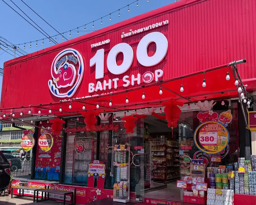 หน้าร้านอาคารสีแดงติดป้าย 100 BAHT SHOP และตราช้าง ในเวลากลางวัน
